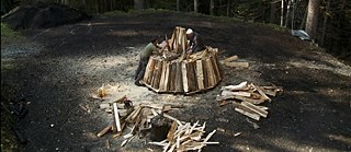 Köhlernächte, Szenenbild: zwei Männer schichten Holz übereinander