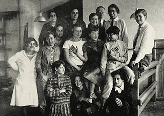 Foto em grupo da sala de aula de tecelagem de Gunta Stölzl (com gravata) por volta de 1927