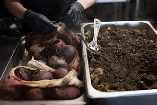 Sous chef Maxime Gnojczak uncovers the beetroot which have been baking in soil