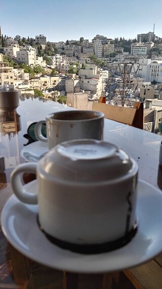 Ein Tisch mit zwei Kaffeetassen auf einer Terrasse mit Blick auf Amman
