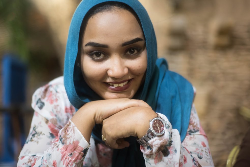 Bild der Fotografin Eythar Gubara, eine Muslimin, die in die Kamera lächelt