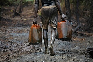<b>Un daño permanente al medio ambiente por el petróleo</b><br>La extracción de combustible es otro ejemplo: compañías multinacionales de energía, subvencionadas por la UE, extraen desde hace décadas petróleo en el delta del río Níger, en Nigeria. Los grandes beneficiarios son, sobre todo, las empresas occidentales y las élites locales. Una gran parte del petróleo se exporta a la Unión Europea. La contaminación ambiental y la destrucción de áreas agrícolas provocadas por el petróleo privan a la población de sus fuentes de subsistencia y provocan pobreza y enfermedad. Cada año cientos de miles de barriles de petróleo se filtran por tuberías agujeradas. Además, muchas empresas petroleras no obedecen las leyes nigerianas y promueven las estructuras corruptas.