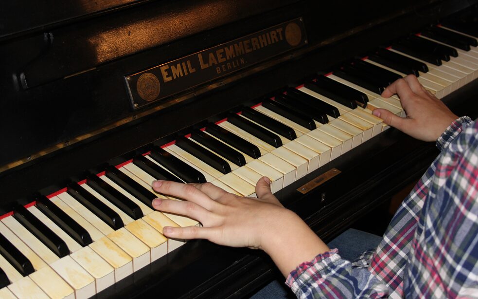Foto von klavierspielenden Kinderhänden.