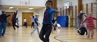 Tanzende Kinder in einer Turnhalle