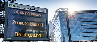 Ein Schild an der Straße, die am Messegelände vorbei in die Stadt führt, rät am Morgen "Abstand halten! Zuhause bleiben! Bleibt gesund!"