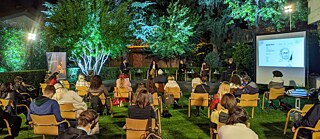 Abendliche Diskussionsrunde unter Bäumen: Erzähle mir von Europa in Tirana, Albanien