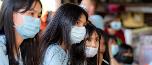 Close-up of schoolgirls with mouth-nose protection.