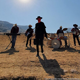 Bandmitglieder von Future Kult stehen mit ihren Instrumenten auf der Wüste