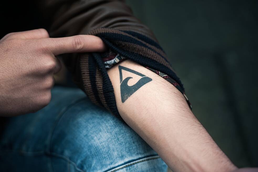 Standbild aus der Netflix Deutschland Serie "We are the wave/ Wir sind die Welle" Rahim zeigt seinen Tattoo des Welle Logos