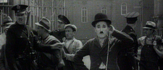 Standbild mit Charlie Chaplin, der von streikenden Arbeitern umgeben ist, die mit der Polizei kämpfen