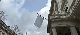 Weiße Fahne vor dem Goethe-Institut London an einem grauen, regnerischen Tag