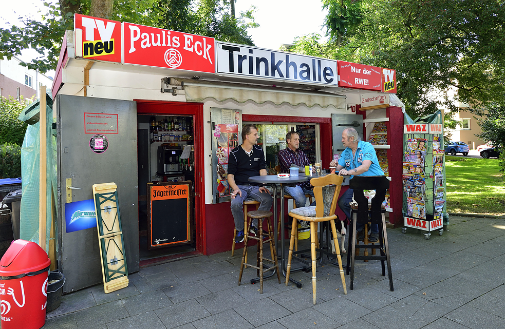 Trois hommes assis devant le troquet Pauli's Eck à Essen