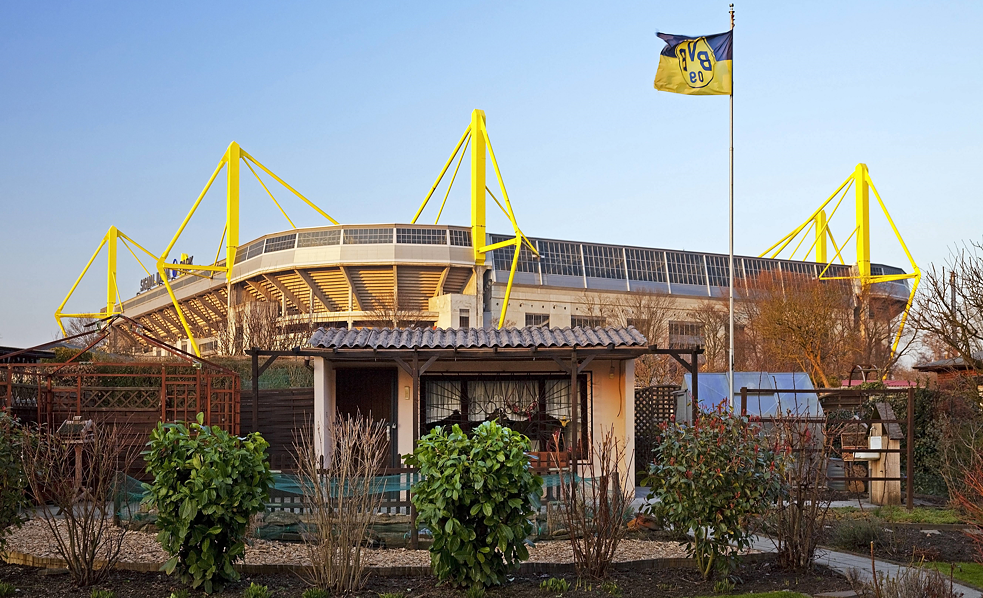 Un huerto en primer plano, el Westfalenstadion del Borussia Dortmund al fondo.