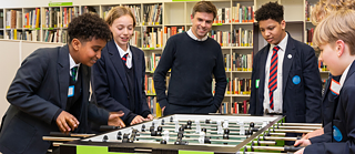 Students and teacher playing table football