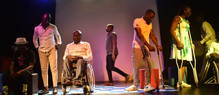 Menschen auf der Bühne mit einem Mann im Rollstuhl.