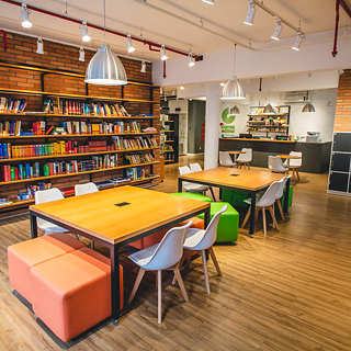 Foto mostra espaço da Biblioteca do Goethe-Institut Porto Alegre com mesas e cadeiras móveis