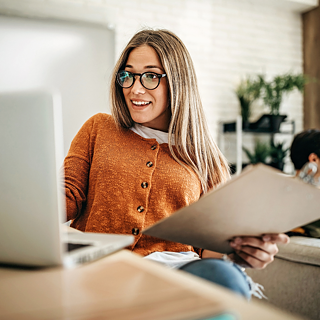 Woman sitting in front of a laptop smiling