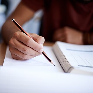 Ein Student schreibt während einer Prüfung auf einen Block (1500)