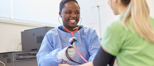 A smiling nurse measures blood pressure