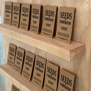 Close up of shelves with brown seed packets reading "seeds of tomorrow"