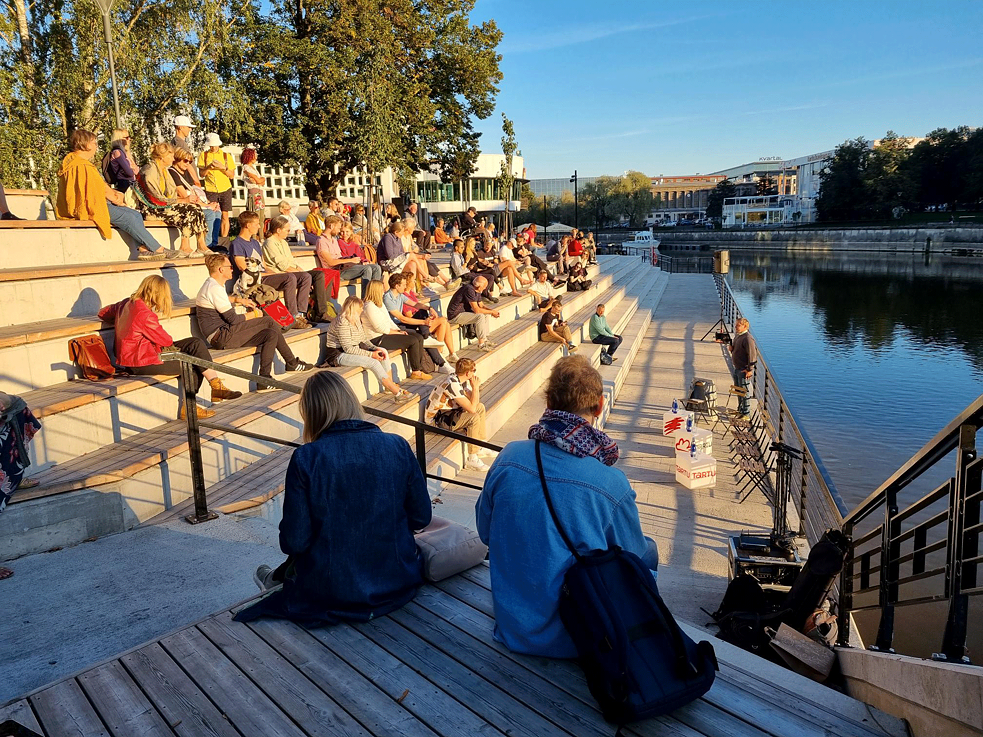 People sitting in front of the river bank