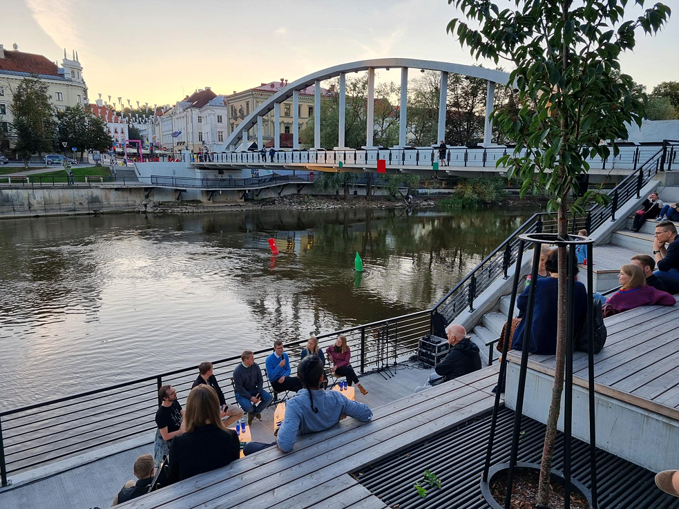 People sitting in front of the river bank