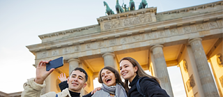 Friends taking a selfie at the Brandenburger Gate in Berlin