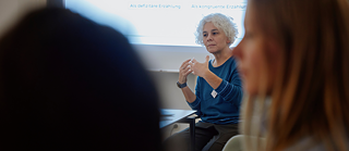 Porträtfoto von Letícia Milano an einem Konferenztisch