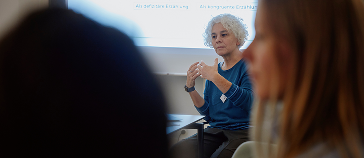 Portrait de Letícia Milano à une table de conférence