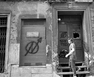 Symbolem squatterského hnutí byl kruh, ve kterém se nachází blesk ve tvaru písmena N – zde je zachycen na zchátralém obytném domě v ulici Oranienburger Straße ve východním Berlíně, vyfotografováno v létě roku 1990